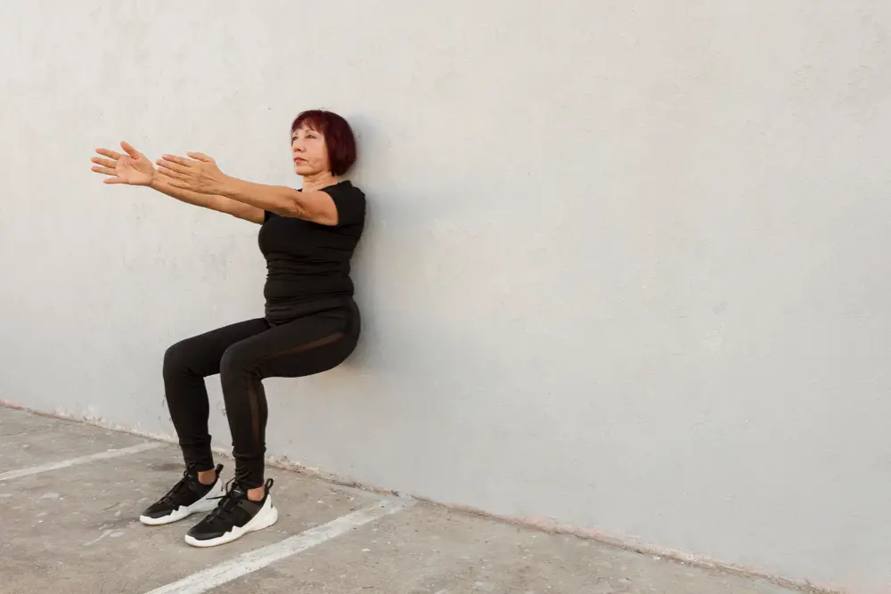 Wand-Pilates zum Abnehmen: Eine Frau beim Wand Squat